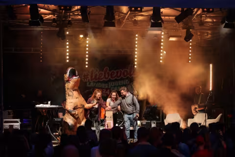 Eine Band mit einem Dino auf der Bühne